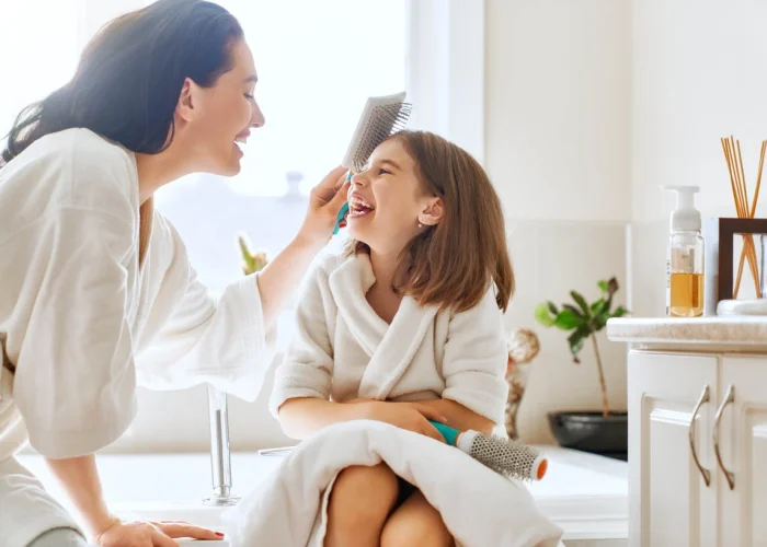 Mother takes care of her daughter hair
